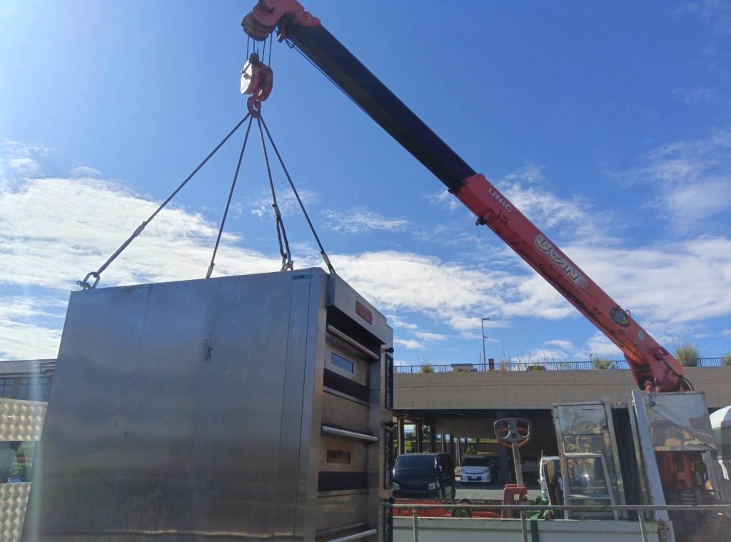 クレーンで運ばれる厨房機器